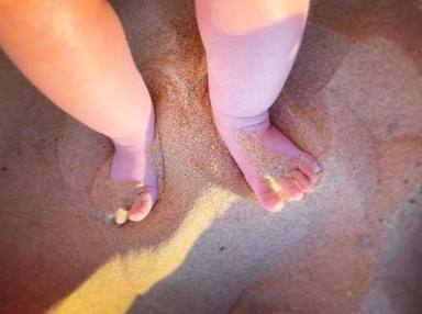 Los pies de Lola, la hija de Toñi Moreno, pisando la playa por primera vez